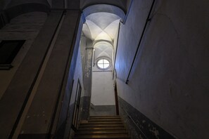 A narrow stairway with a circular window at the top, leading to a higher floor. - La Stanza del Principe (Naples)