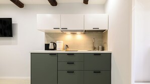 Une cuisine moderne équipée d’une cuisinière intégrée, d’une machine à café et d’un évier.
