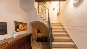 Una escalera con barandilla de madera y una pared decorada con cuadros.
