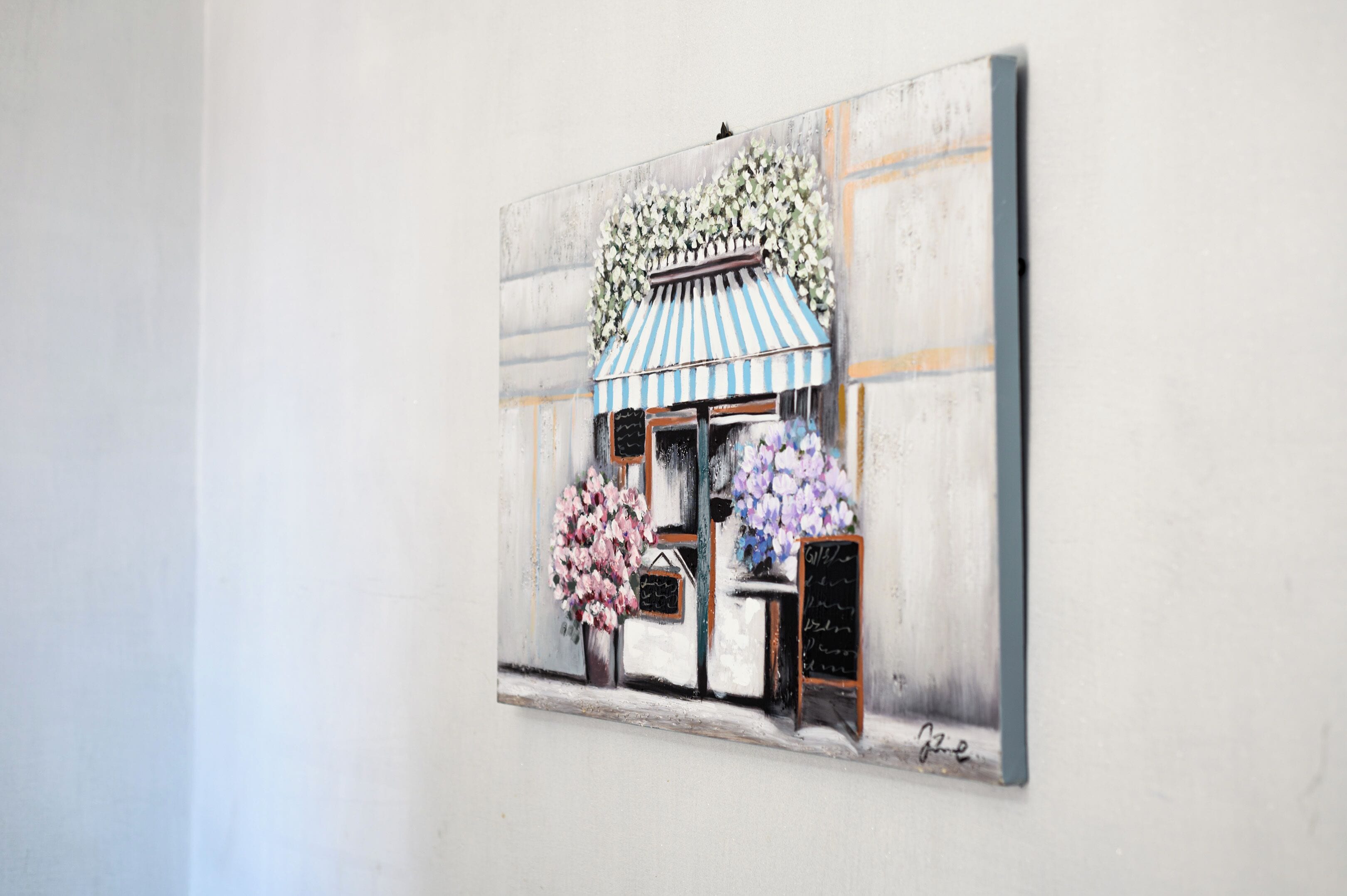 A painting of a storefront with a striped awning, flowers, and a chalkboard sign.