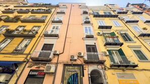 A multi-story building with balconies, air conditioning units, and storefronts including 'GameStop' and 'TOLEDO72'. - Santa Patrizia a Chiaia Apartment - Terra (Naples)