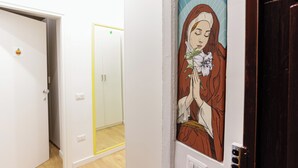 Een gang met een deur waarop een kunstwerk met religieus thema is afgebeeld.
