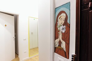 Un pasillo con una puerta que presenta una obra de arte de temática religiosa.
