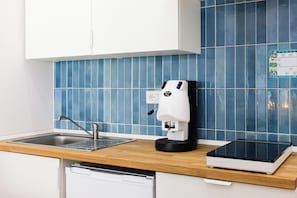 A kitchen with a coffee machine, a dishwasher, and a tablet on the counter. - Santa Patrizia a Chiaia Apartment  (Naples)