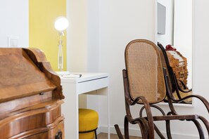 A room with a white desk, a yellow chair, a wooden chair, and a lamp. - Santa Patrizia a Chiaia Apartment  (Naples)