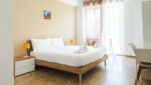 Un dormitorio con una cama de madera, dos mesitas de noche con lámparas, un escritorio y una silla.