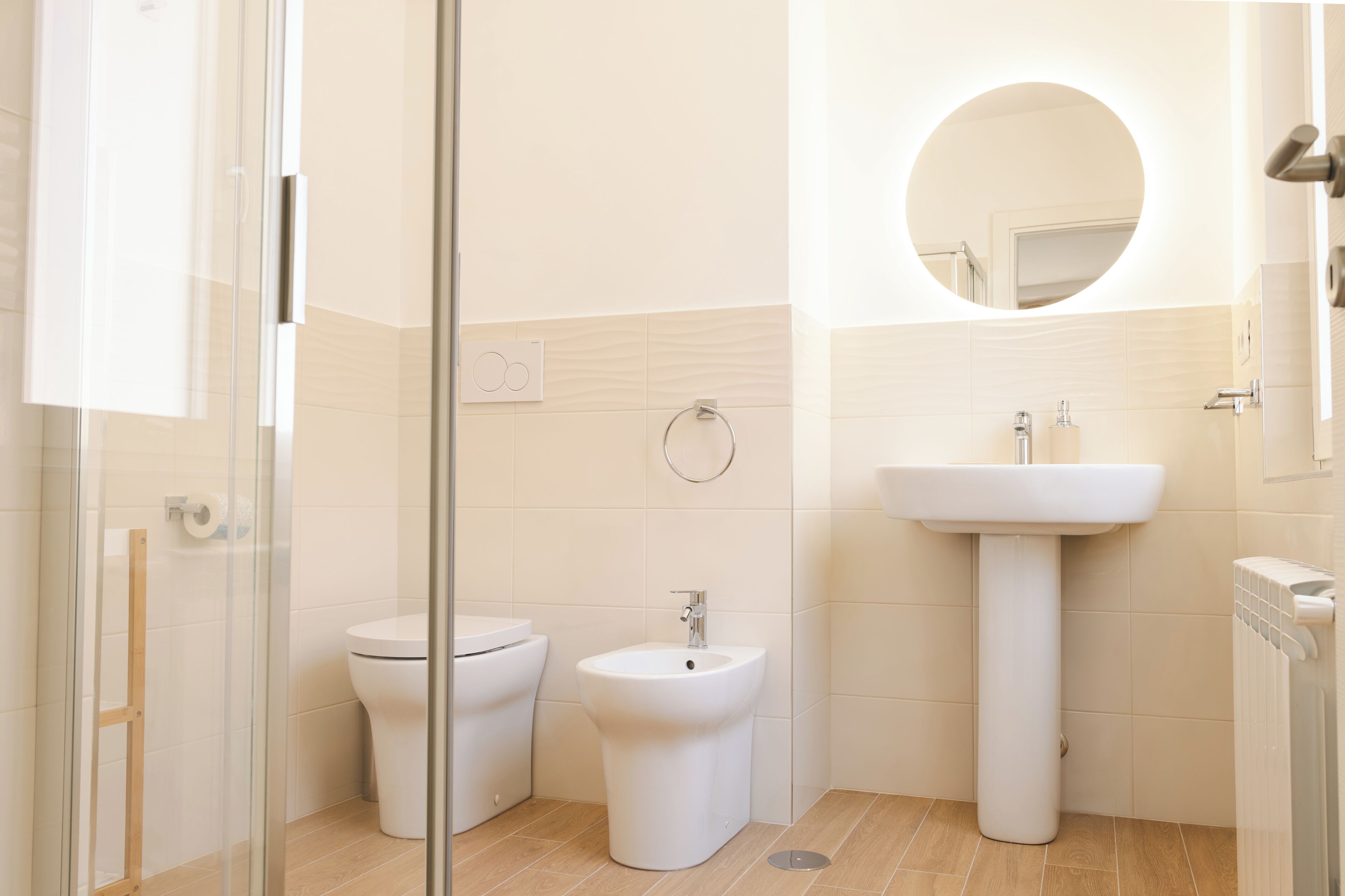 A modern bathroom with a toilet, bidet, and sink.