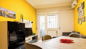 Eine moderne Küche mit Essbereich, ausgestattet mit einem schwarzen Kühlschrank, einer weißen Arbeitsplatte und einem Esstisch mit einer roten Tischmatte.