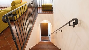 Un escalier avec une rampe métallique menant à un palier.
