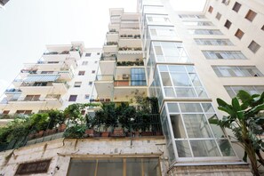 A multi-story residential building with balconies, large windows, and potted plants. - Riviera di Chiaia 207 - 7° Piano (Naples)
