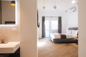 Un dormitorio moderno con cama, mesita de noche y vistas al exterior a través de una ventana.