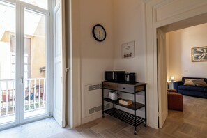 Ein modernes Wohnzimmer mit einer Couch, einem Couchtisch und einem Beistelltisch. Ein Fenster bietet Blick ins Freie.