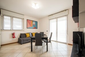 A modern living room with a dining table, chairs, a sofa, and a flat-screen TV. - Residenza Arcimboldi (Milan)