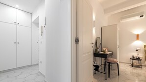 A modern bathroom with a vanity, mirror, and a small table with a lamp. - La Favola di San Martino (Naples)
