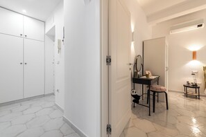Un bagno moderno con un mobile lavabo, uno specchio e un piccolo tavolino con una lampada.
