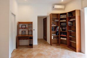 Un couloir avec un bureau en bois et des étagères remplies de livres.