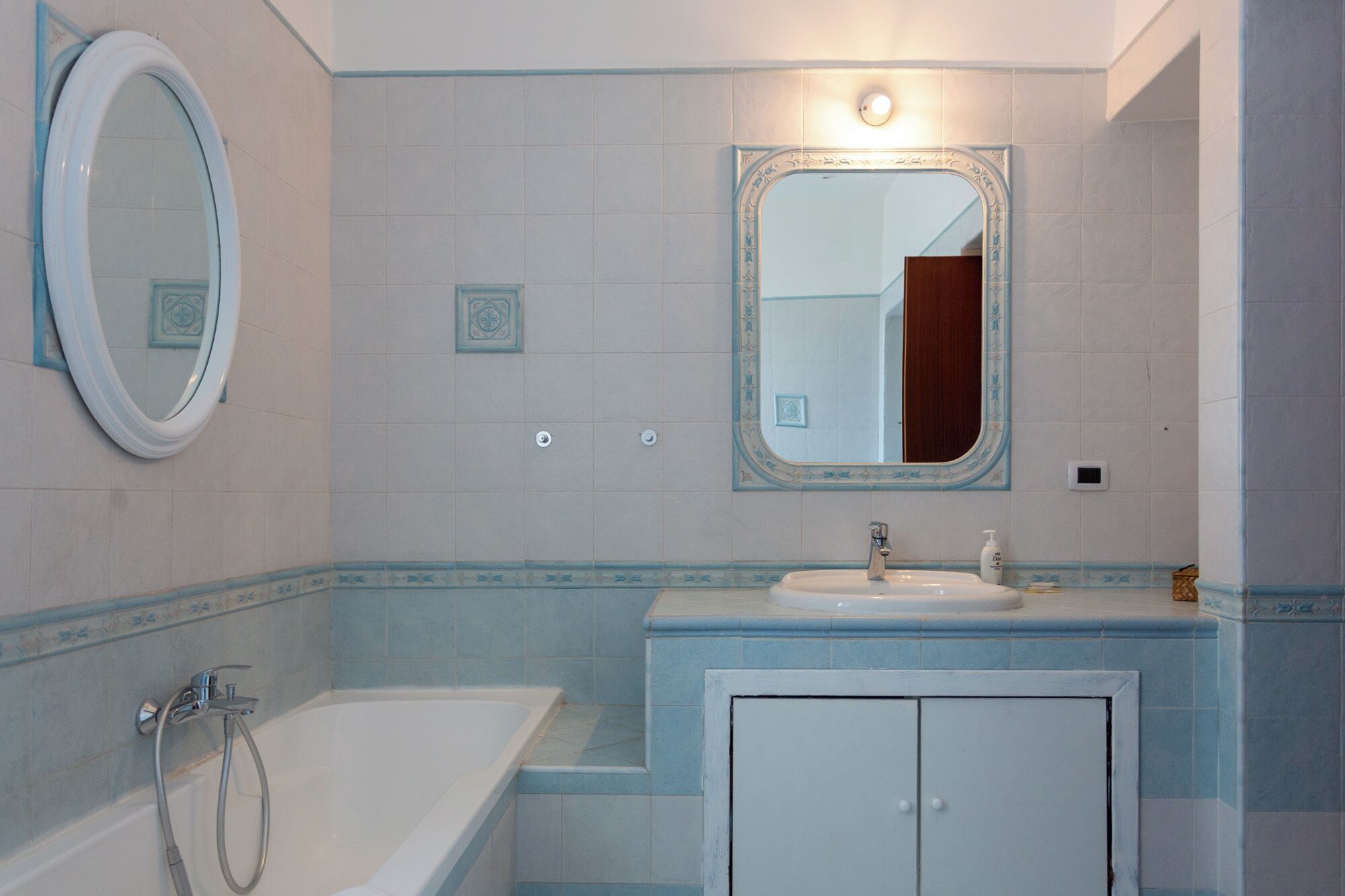 Une salle de bain avec une baignoire, un lavabo et un meuble de rangement.