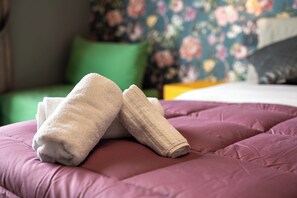 A bed with a purple bedspread and two folded towels on it. - Zapata Relais - Chiaia (Naples)