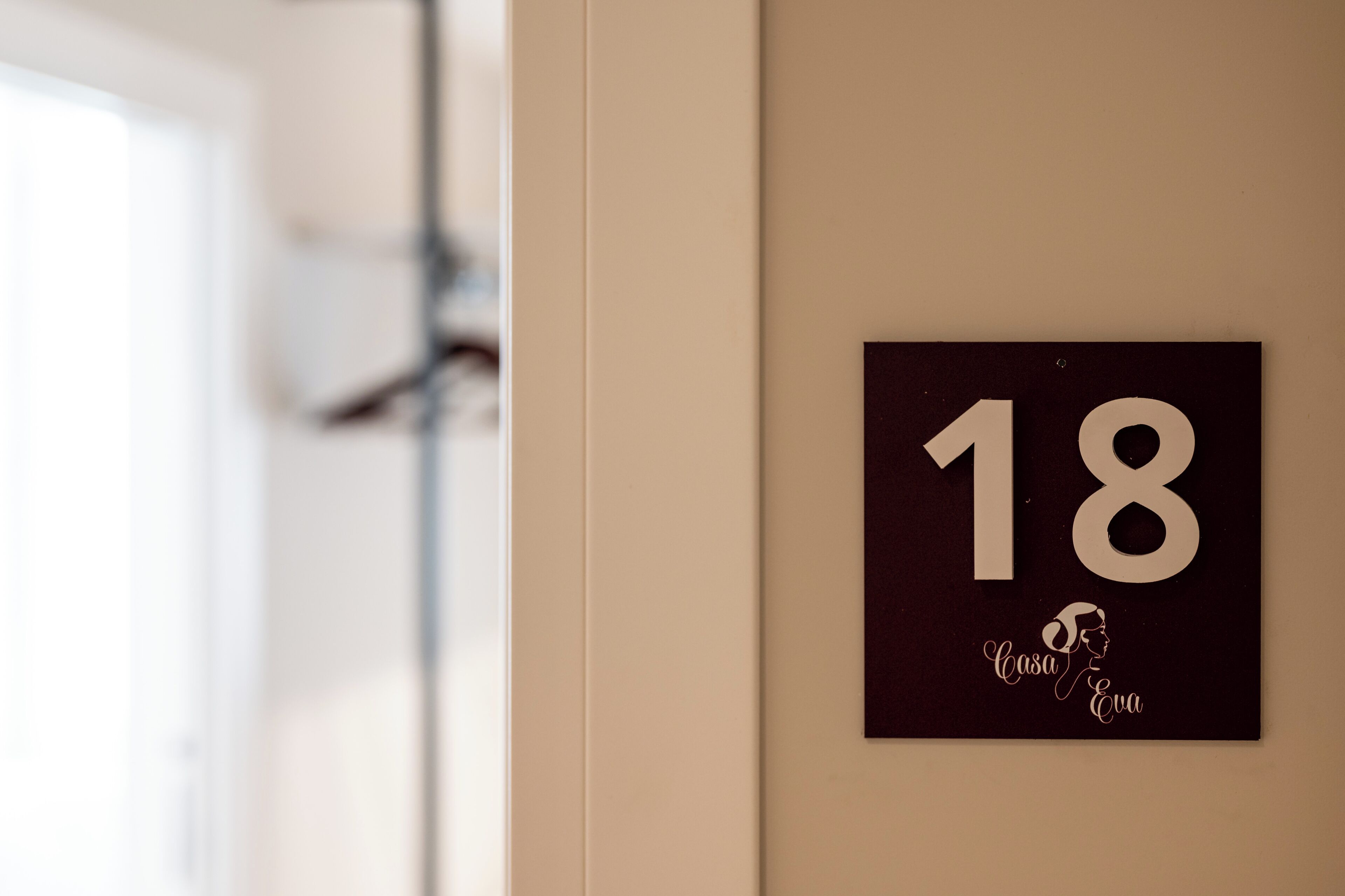 A wall-mounted sign with the number 18 and the text 'Casa Eva' below it.