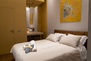 A hotel room with a bed, a desk, and a painting on the wall. - Via Chiaia 123 - Camera Oltremare (Naples)