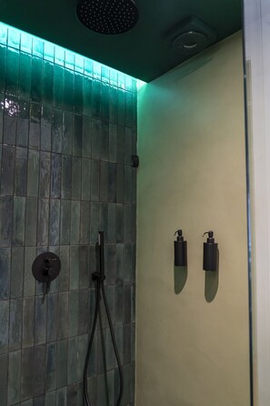A bathroom with a tiled wall, a showerhead, and two hand dryers. - Via Chiaia 123 - Camera Oltremare (Naples)