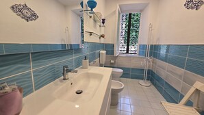 Casa de banho com banheira, sanita e lavatório.