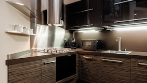 Eine moderne Küche mit Edelstahlgeräten, Holzschränken und einem eingebauten Backofen.