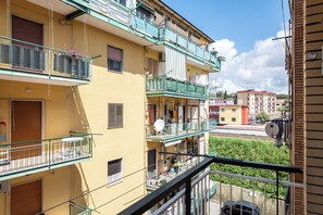 A multi-story residential building with balconies, satellite dishes, and a clear view of the street below. - Sea Breeze (Naples)