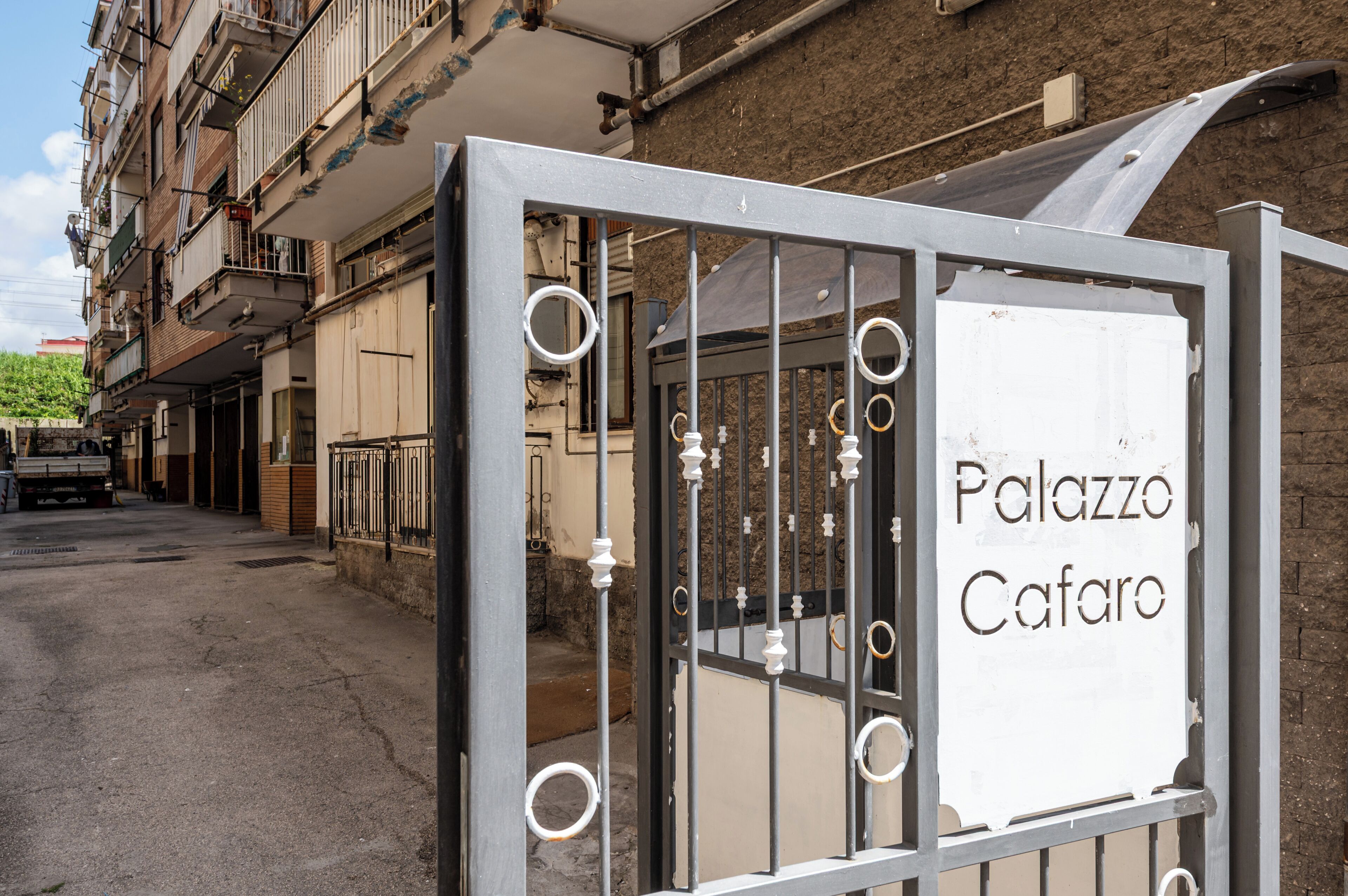 A gated entrance to a building with a sign reading 'Palazzo Cafaro'.