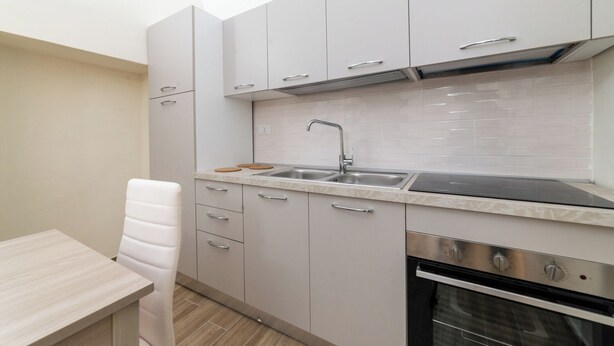 Una cocina compacta con un lavabo, estufa y armarios.