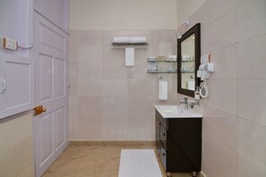 A bathroom with a white sink, a mirror, a towel rack, and a hairdryer on the wall. - Brij Villa Dalhousie A Colonial Luxury Retreat (Dalhousie)
