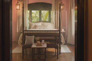 Un dormitorio con cama, mesitas de noche y una ventana con cortinas.