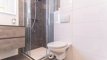 Eenvoudig appartement | Badkamer | Een douche, gratis toiletartikelen, een haardroger, handdoeken