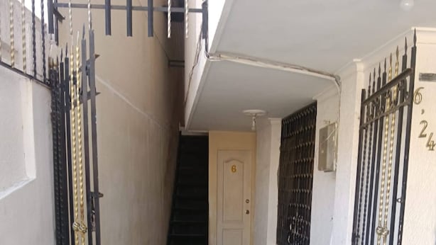 A narrow hallway with a tiled floor, a staircase, and two gated entrances. - Studio 3 Paisible 5 Minutes From El Rodadero Beach (Santa Marta)