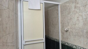 A bathroom with a toilet, a shower stall, and a roll of toilet paper. - Studio 3 Paisible 5 Minutes From El Rodadero Beach (Santa Marta)
