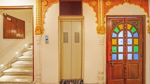 An elevator, a wooden door with stained glass, and a staircase. - Palette Hotel and Resorts Jodhpur (Jodhpur)