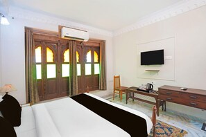 A hotel room with a bed, a desk, a chair, an air conditioner, and a television. - Palette Hotel and Resorts Jodhpur (Jodhpur)