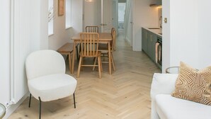 Un intérieur moderne comprenant un coin repas, un canapé et une cuisine.