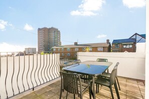 A rooftop terrace with a table and chairs, a decorative star, and a view of surrounding buildings. - ✨ Stylish 3-Bed Victorian Maisonette in Queens Park (Brighton and Hove)