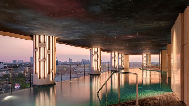 An indoor infinity pool with a city view, modern architecture, and a starry ceiling. - Vasa Suite Surabaya (Surabaya)