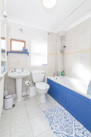 A bathroom with a toilet, sink, and bathtub.