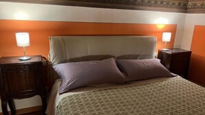 A hotel room with a bed, two bedside tables, and a decorative ceiling. - Tosca (Florence)