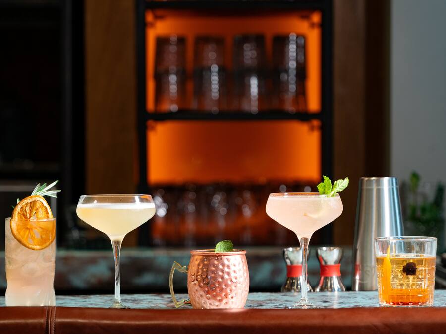 A bar setting with various drinks and a copper mug.
