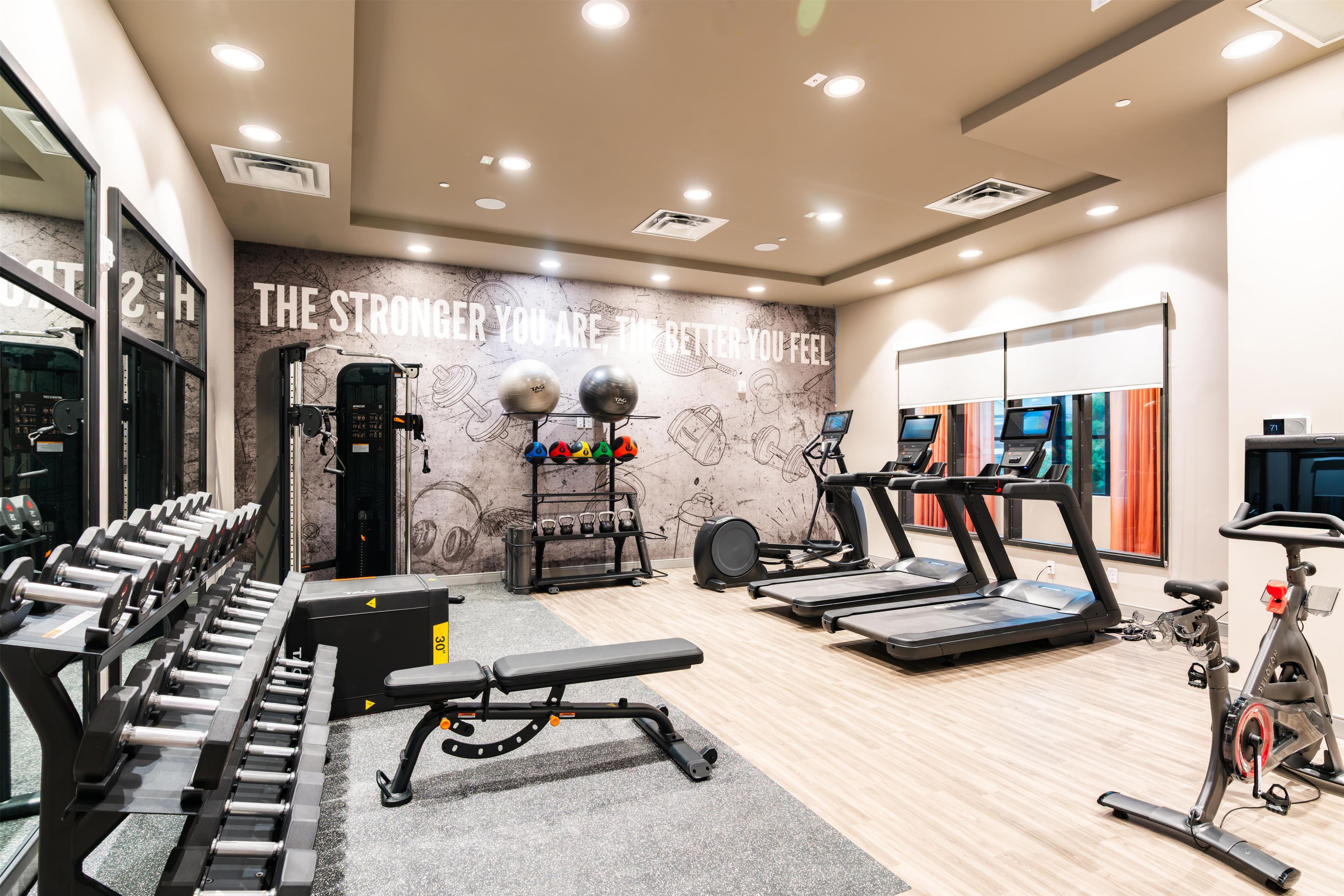 A gym with weightlifting equipment, treadmills, and a motivational wall.
