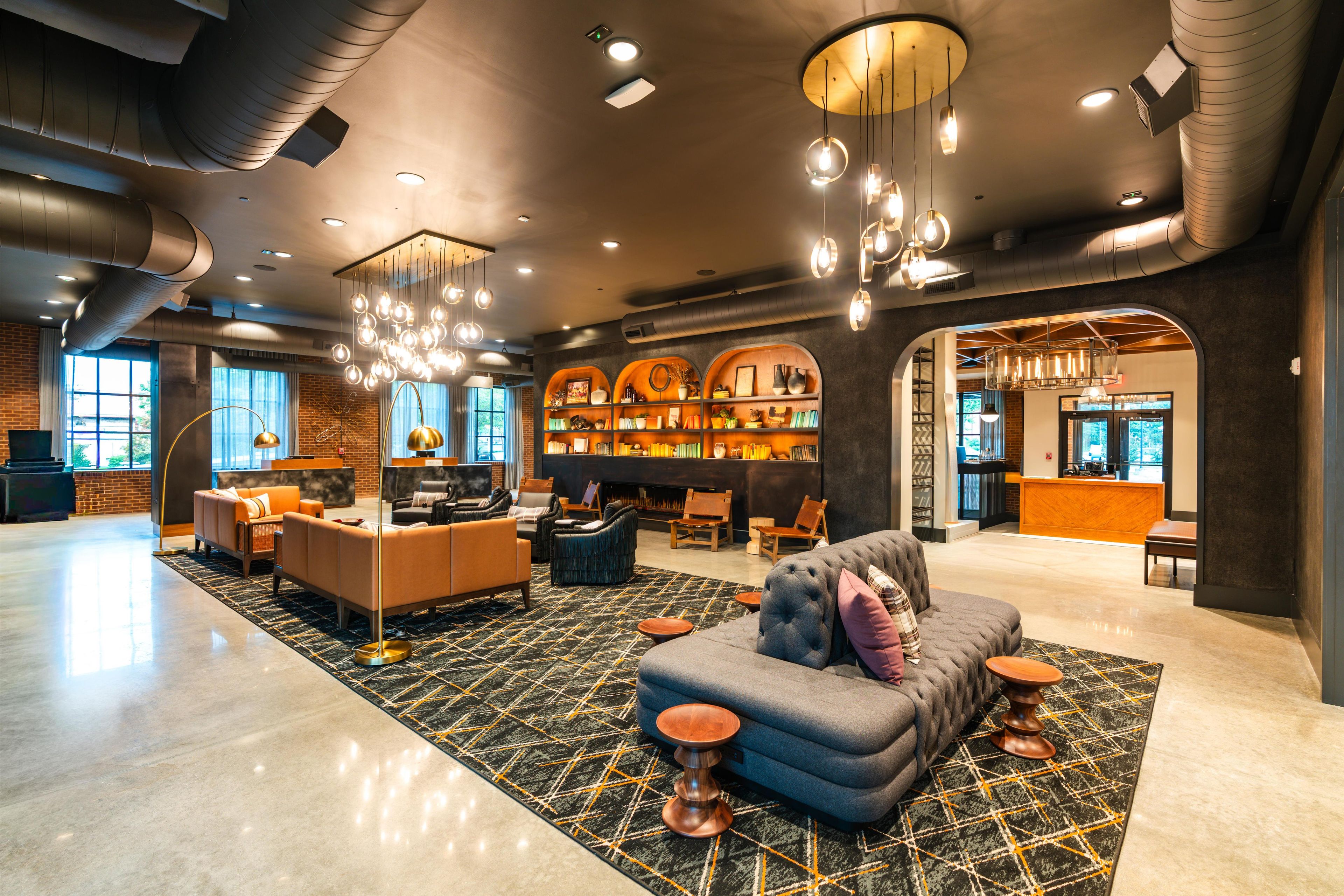 A spacious lobby with a central seating area, a fireplace, and a bar.