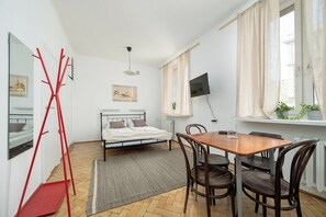 Ein Schlafzimmer mit Bett, Nachttisch und Fernseher an der Wand.