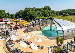 A pool area with a dome structure, sun loungers, and a water slide. - COTTAGE PARKS LA FORÊT - 3 bed 6 bath mobile home in the heart of the chateau park (Saint-Julien-des-Landes)