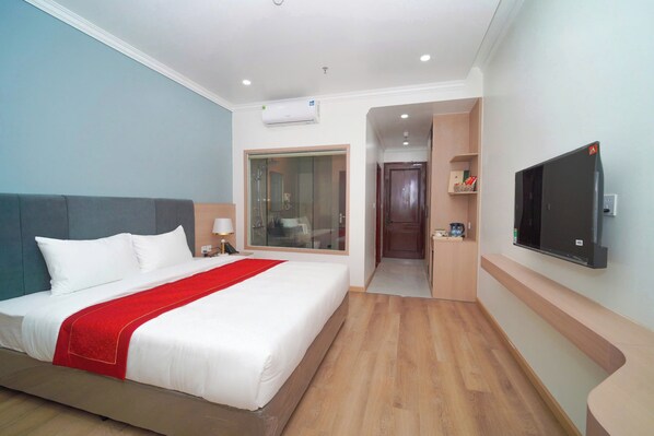 Habitación de hotel con cama, televisión, ducha y vestidor.