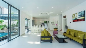 Un salon moderne comprenant un canapé, une table basse et un coin repas avec des chaises et une table.