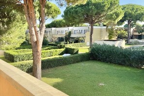 Ein Wohngebiet mit ordentlich geschnittenen Hecken, Bäumen und einem Gebäude mit vielen Fenstern.